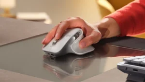 a woman holding the logitech mx master 3S mouse at a desk