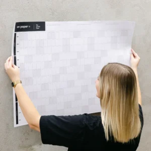 yearly wall calendar placed on a wall by a young female entrepreneur