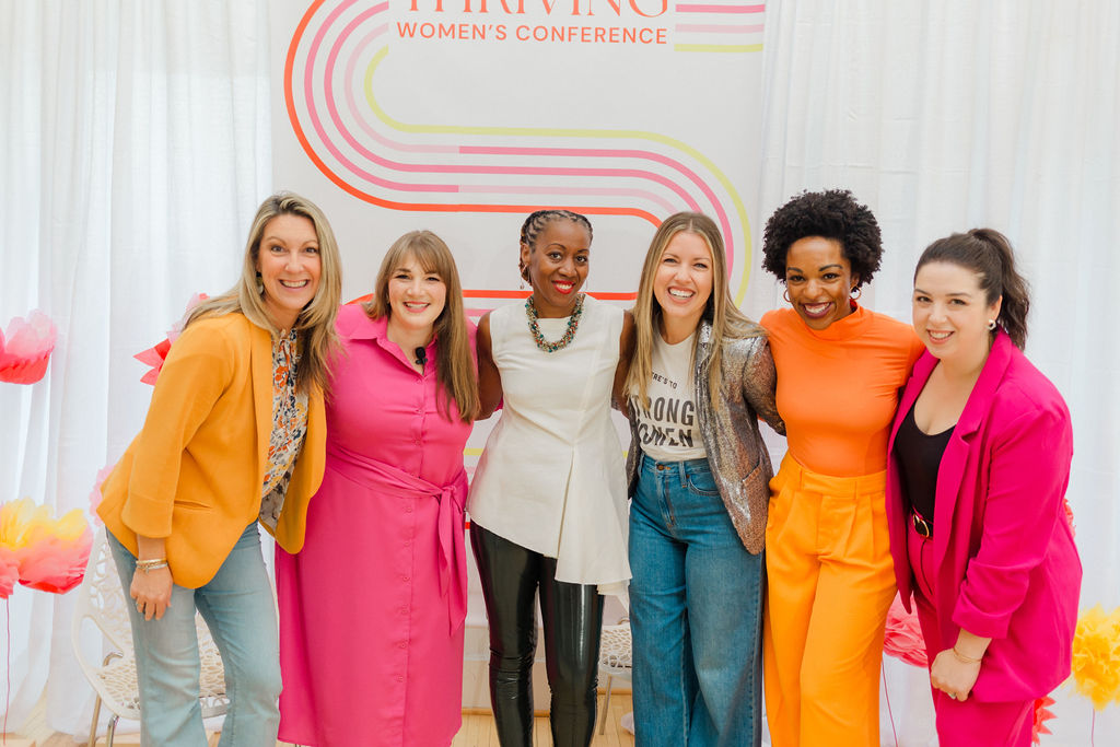 a diverse group of successful business women at thriving women's conference