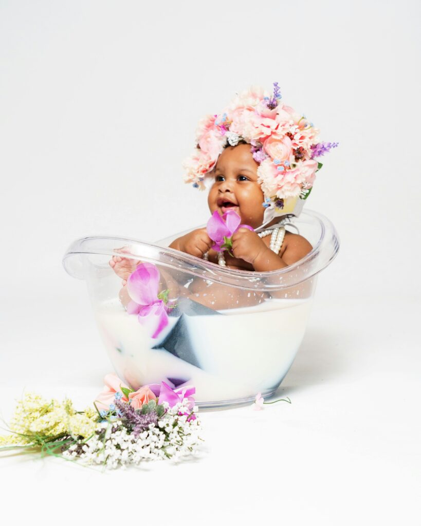 a cute newborn baby covered in flowers for a photoshoot