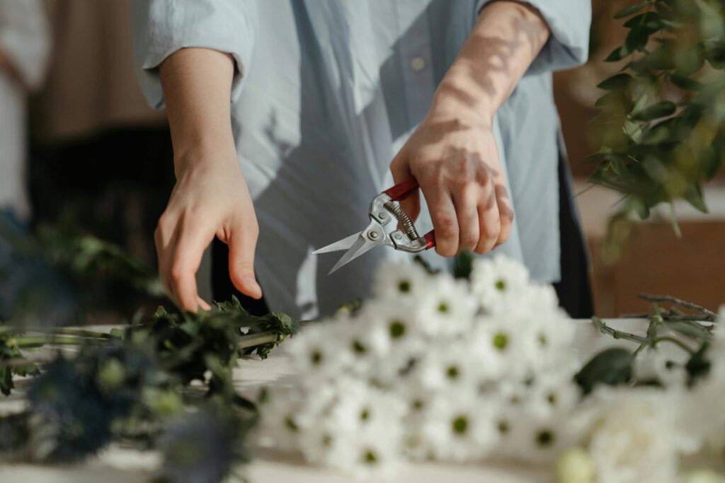 a florist business owner preparing flowers to be arranged into a bouquet