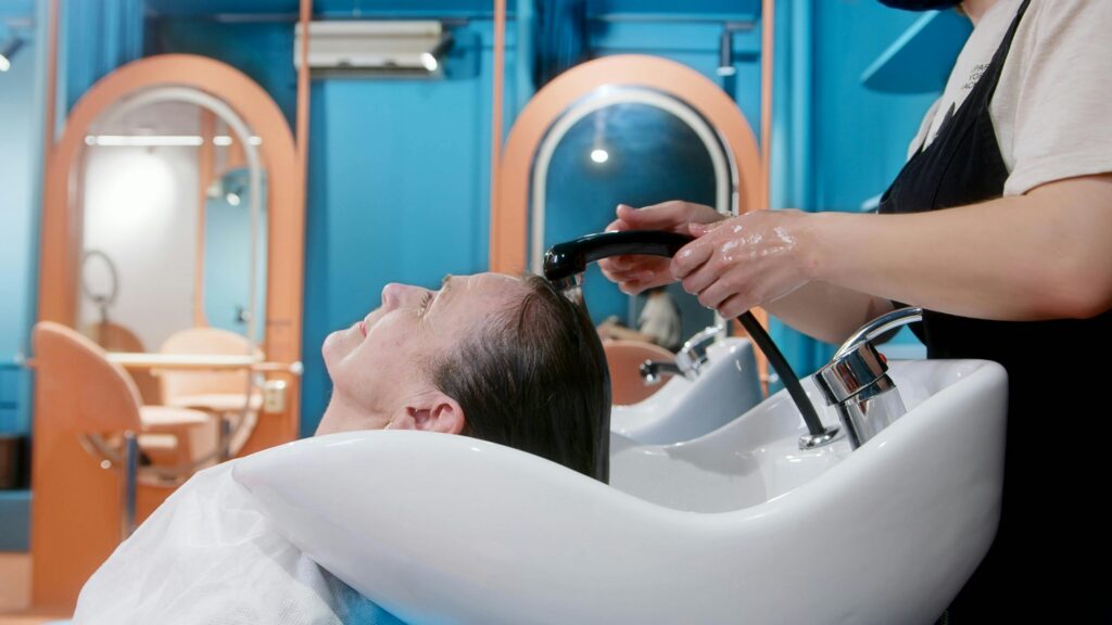 a middle aged woman getting her hair washed before a hair cut at a trendy hair salon
